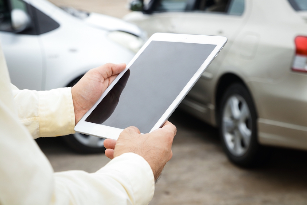 A man uses auto transport software on his tablet