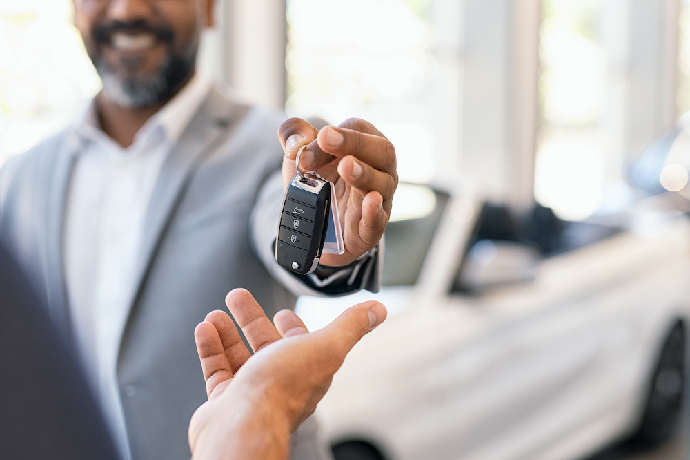 Car dealership handing over keys to customer