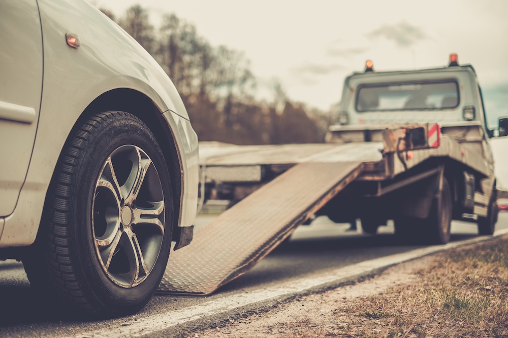 A car being loaded up on a trailer