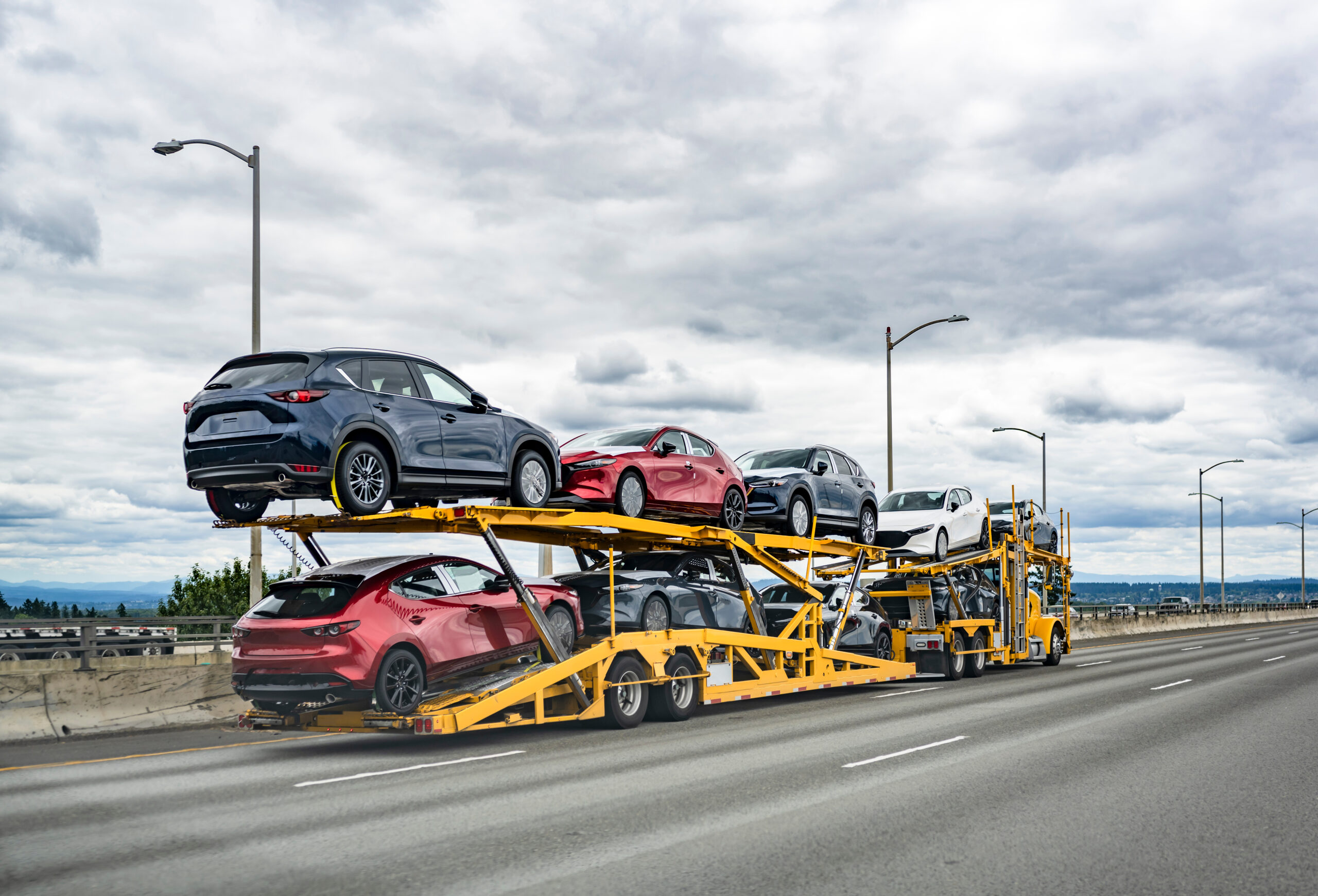 yellow car hauler on the road
