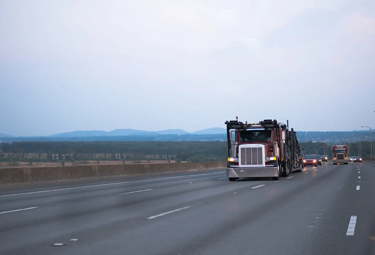 american transporter car hauler truck driving on a highway